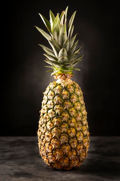 Ananas entier sur fond sombre.