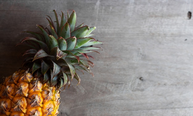 Ananas sur fond de bois ancien. vue de dessus. sur la lumière