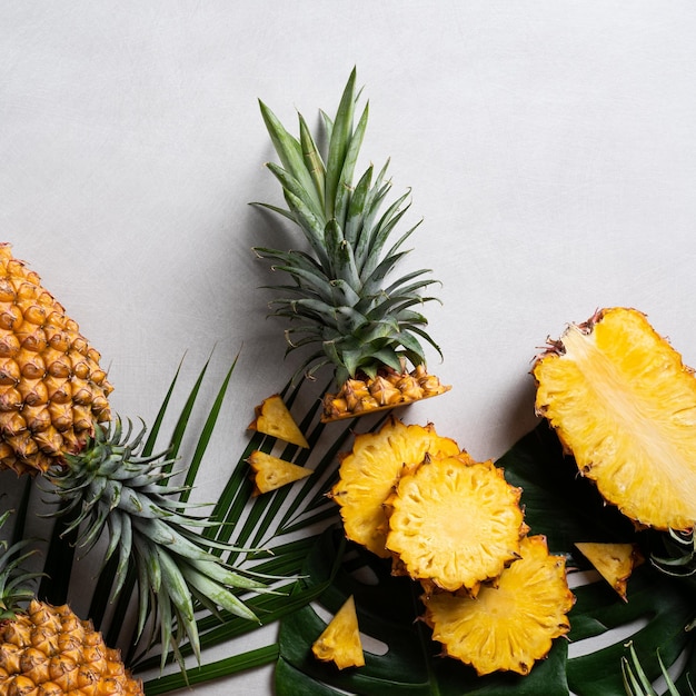 Ananas frais coupé avec des feuilles tropicales sur fond bleu foncé