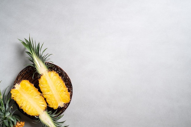 Ananas frais coupé avec des feuilles tropicales sur fond bleu foncé