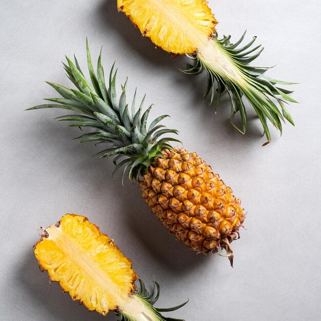 Ananas frais coupé avec des feuilles tropicales sur fond bleu foncé