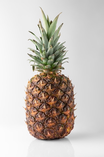 Ananas frais mûr isolé sur fond blanc et gris avec une ombre naturelle. concept de voyage avec espace de copie