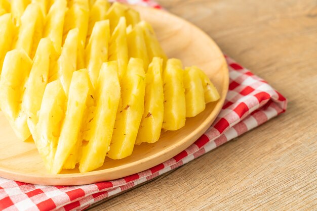 ananas frais tranché sur plaque de bois