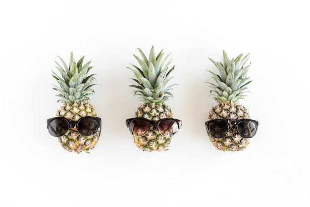 Ananas hipster dans des verres sur fond blanc Vue de dessus à plat