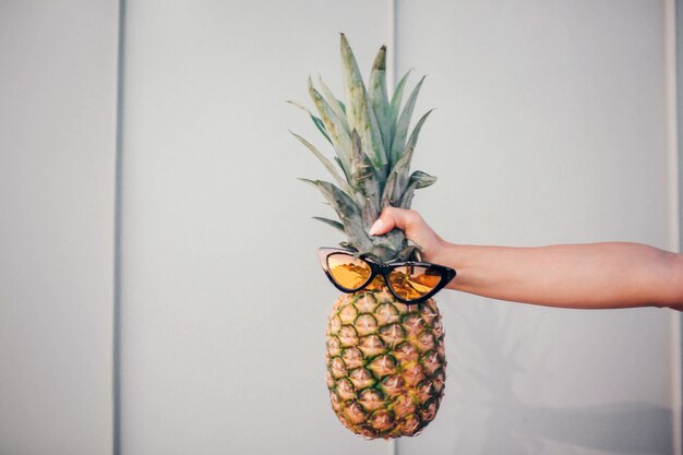 ananas avec lunettes de soleil isolé sur rayé et blanc