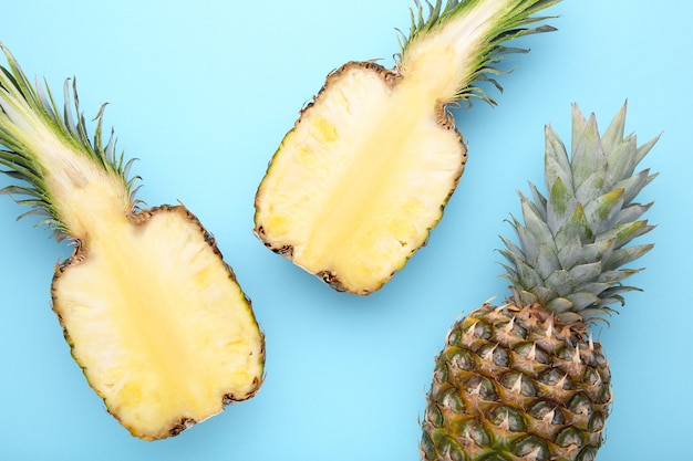 Ananas et moitié d&#39;ananas sur fond bleu