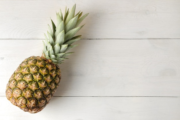 Ananas mûrs sur une table en bois blanc. l'été. vue de dessus.