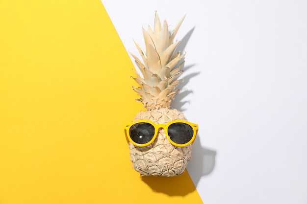 Ananas or peint avec des lunettes de soleil sur fond bicolore