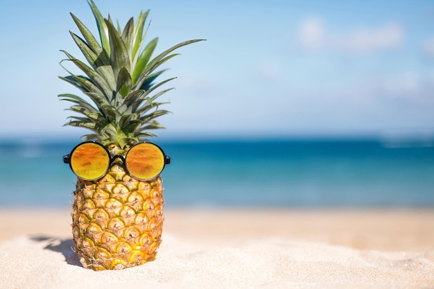 Ananas sur la plage avec ciel bleu et fond de mer