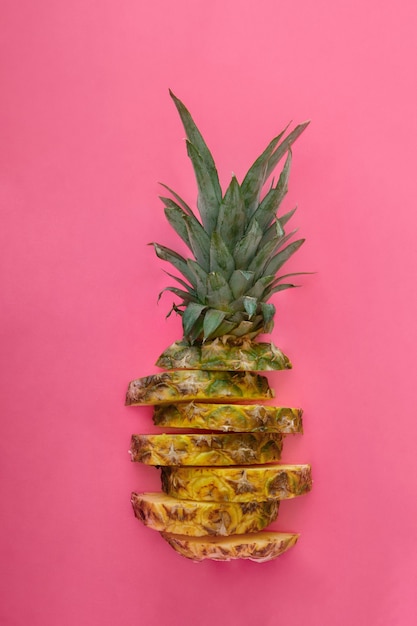 Ananas en tranches sur fond d'été de couleur rose. Fruits tropicaux Anneaux d'ananas tranchés. Composition créative à plat.