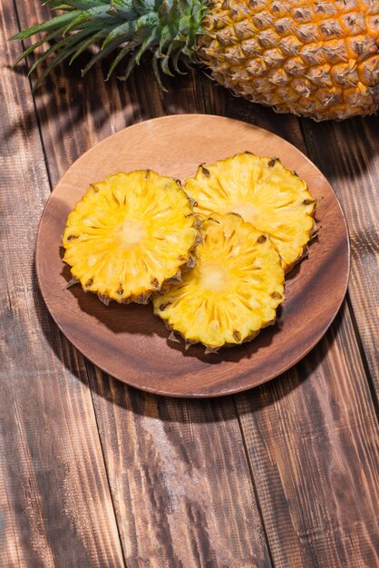 Ananas tranchés frais sur un fond en bois.