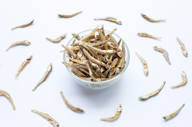 Anchois séchés dans un bol en verre sur fond blanc.