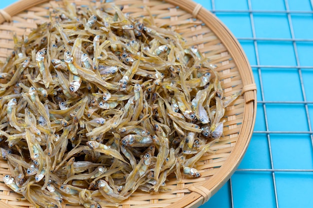 Anchois Séchés Dans Un Panier Rond En Bambou Sur Fond Bleu