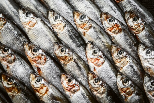 Anchois et sprat de poisson cru frais sur une surface en bois