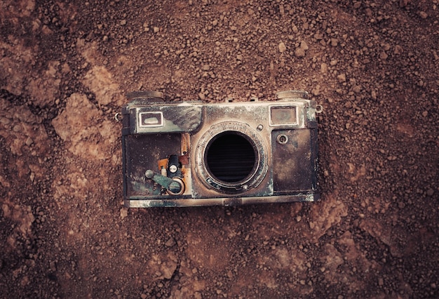 Ancien appareil photo sur sol sec après un incendie de forêt