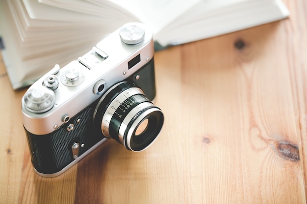 Ancien appareil photo vintage avec livre sur une table en bois