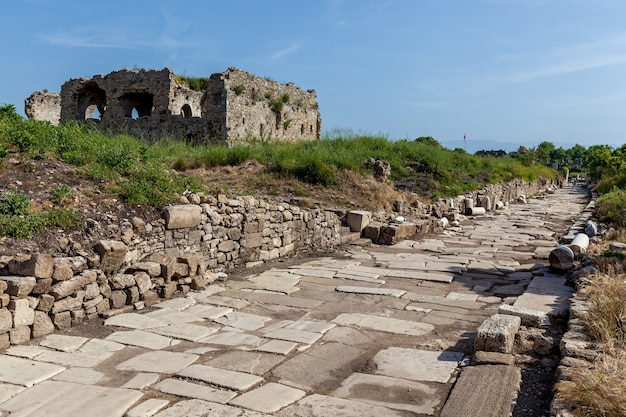 Un ancien bâtiment abandonné près d'un chemin de briques sur fond de ciel bleu à Side.