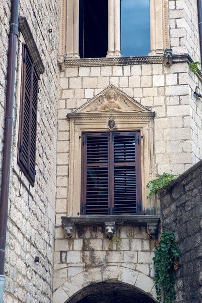 Ancien bâtiment au Monténégro avec fenêtres et volets et lierre