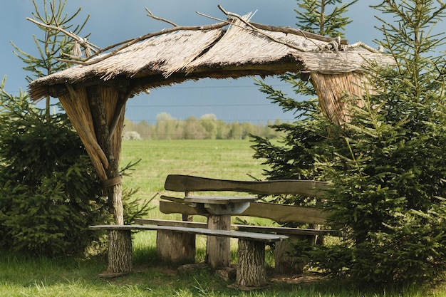 Un ancien belvédère en bois pour se détendre dans le parc Équipé de tables et bancs en bois