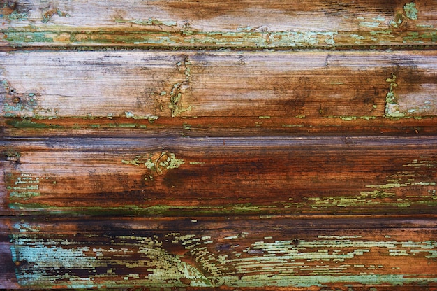 Photo ancien bouclier en bois peint en vert avec rayures et éclats.