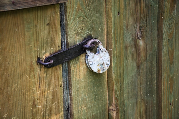 Ancien cadenas en métal fermé par une agrafe en métal