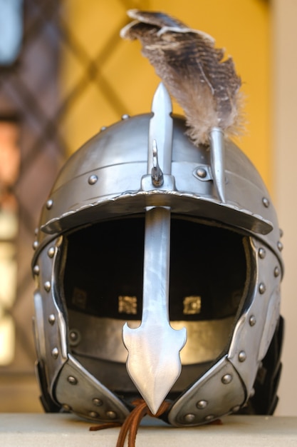 Un ancien casque de chevalier avec une plume. Concept médiéval.