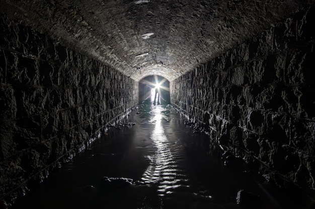 Ancien collecteur en brique de drainage ou d'égout avec lumière au bout