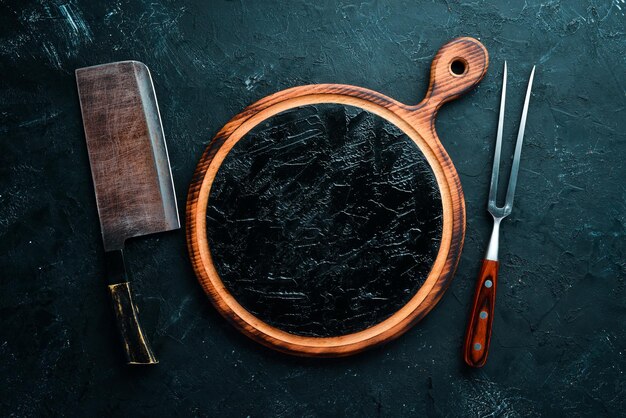 L'ancien couteau de cuisine et planches en bois sur fond noir Vue de dessus Espace libre pour votre texte