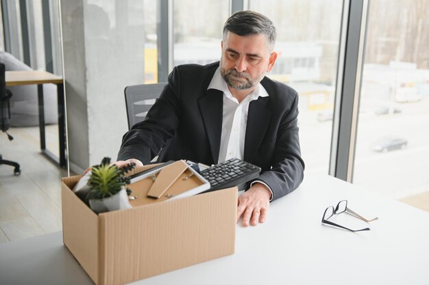 Ancien employé quittant le bureau avec la boîte pleine d'effets personnels