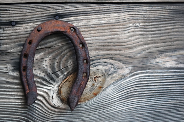 Ancien fer à cheval rouillé sur fond de bois