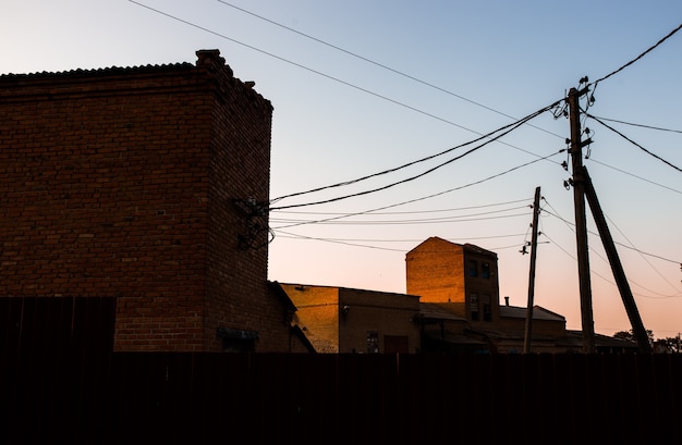 Ancien grenier en briques éclairé par la lumière orange du coucher du soleil.