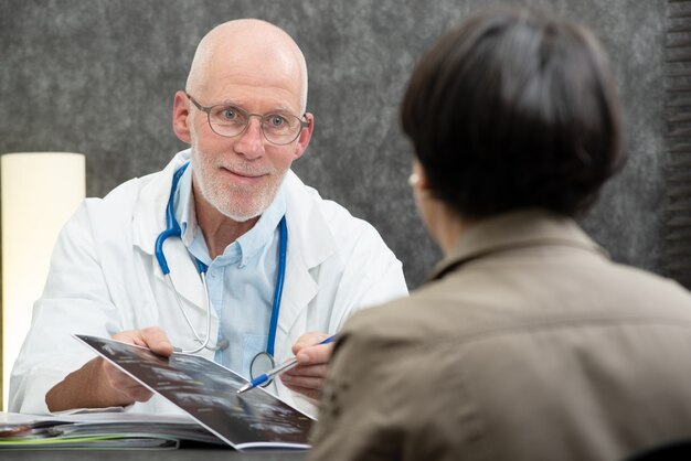 Ancien médecin montrant une radiographie au patient