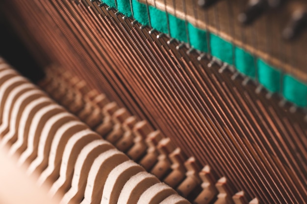 Photo ancien piano acoustique vintage à l'intérieur avec des marteaux et des cordes en gros plan réglage d'un instrument de musique mise au point sélective