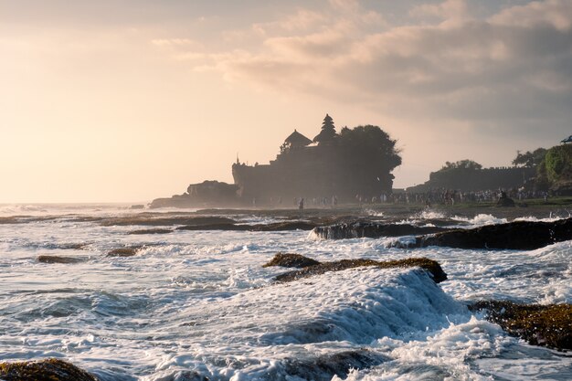 Ancien temple de Tanah Lot sur la montagne rocheuse au littoral