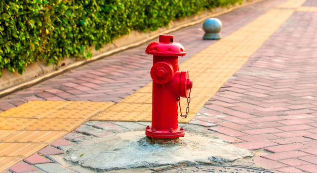 Ancienne bouche d'incendie rouge avec fond de rue.