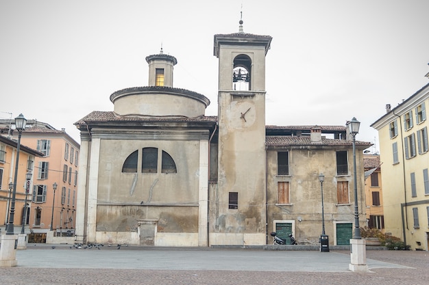 Photo ancienne cathédrale médiévale avec horloge sur le clocher le matin d'hiver ensoleillé. belle église italienne. église de la madonna del lino, piazza del mercato, brescia, italie