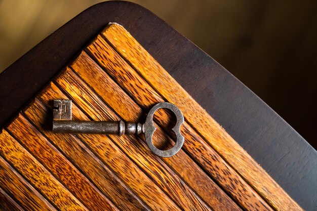 L'ancienne clé se trouve sur une vieille table en bois textures naturelles le concept de découvertes secrets répond