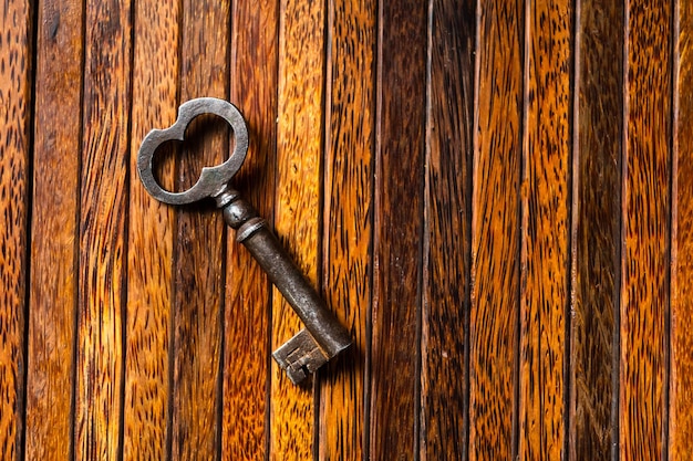 L'ancienne clé se trouve sur une vieille table en bois textures naturelles le concept de découvertes secrets répond