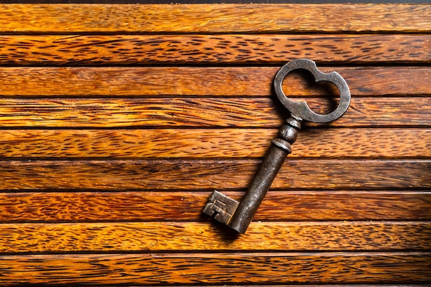 L'ancienne clé se trouve sur une vieille table en bois textures naturelles le concept de découvertes secrets répond