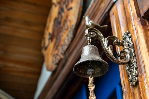 ancienne cloche en bronze placée à côté d'une porte