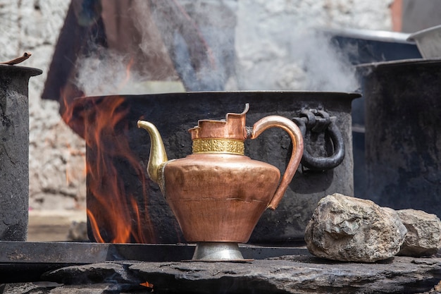 Ancienne cruche en laiton et une grande casserole sur la cuisine dans un monastère tibétain Monastère d'Hemis, Ladakh, état de Jammu-et-Cachemire, Inde du nord, gros plan