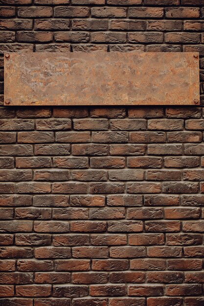 Ancienne enseigne en métal vierge sur un mur de briques brunes. Le signe semble cher.