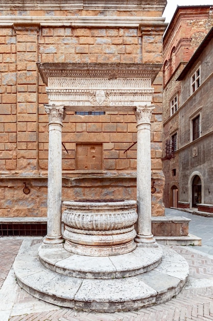 Ancienne fontaine en marbre blanc Piccolomini bien sur la Piazza Pio II à Pienza