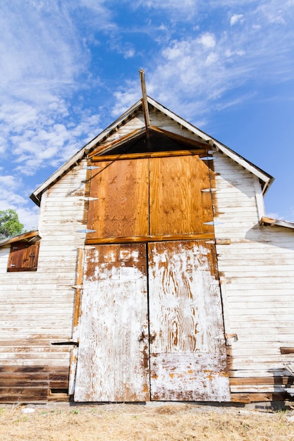 Ancienne grange blanche avec cour de ferme.