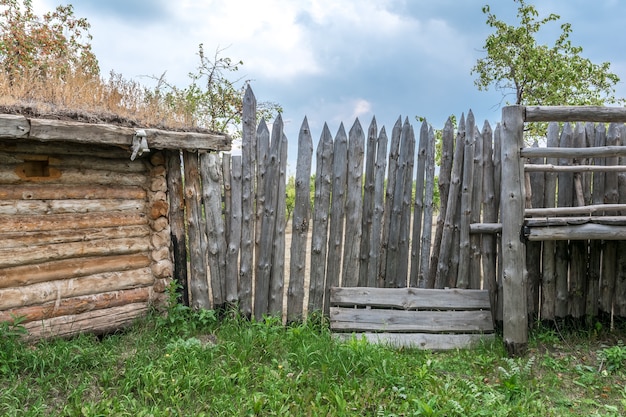 Une ancienne grange en bois et une haute palissade de rondins pointus Protection d'un ancien village russe