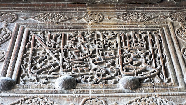 Ancienne inscription sculptée sur une porte en bois