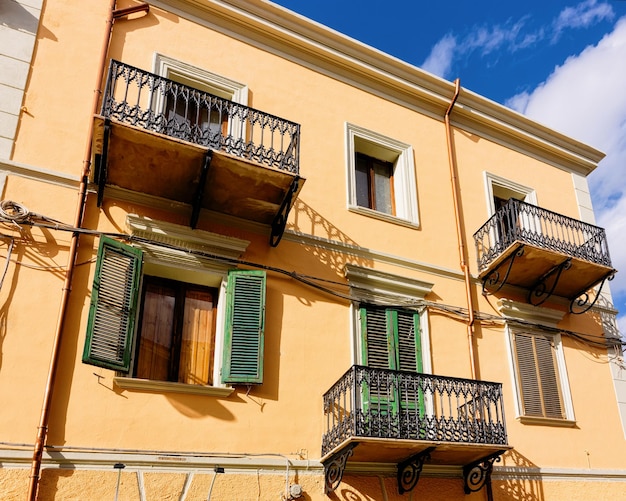 Ancienne maison d'appartements architecture résidentielle avec installations extérieures. Fenêtres avec volets et balcons à la ville d'Olbia sur l'île de Sardaigne en Italie.