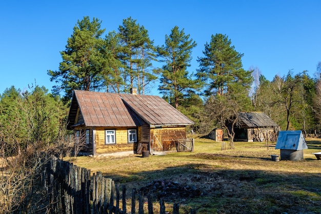 Ancienne maison de campagne en bois dans le village de l'arrière-pays russe à l'aube dans la forêt de pins Tourisme et loisirs écologiques