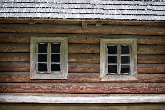 Ancienne maison à ossature bois avec deux fenêtres. Maison en campagne. Rustique.