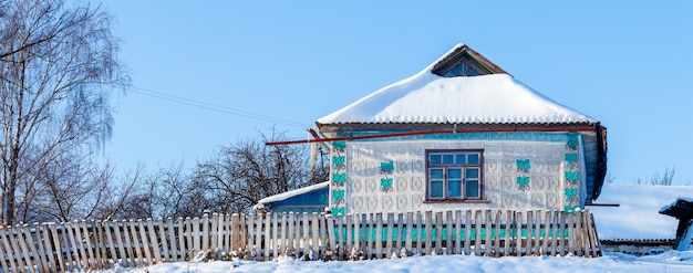 Ancienne maison de village en hiver par temps ensoleillé. Le village en hiver